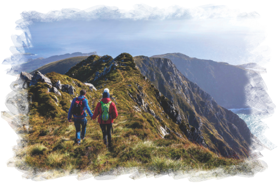 Dos caminantes recorren un sendero entre montañas andinas